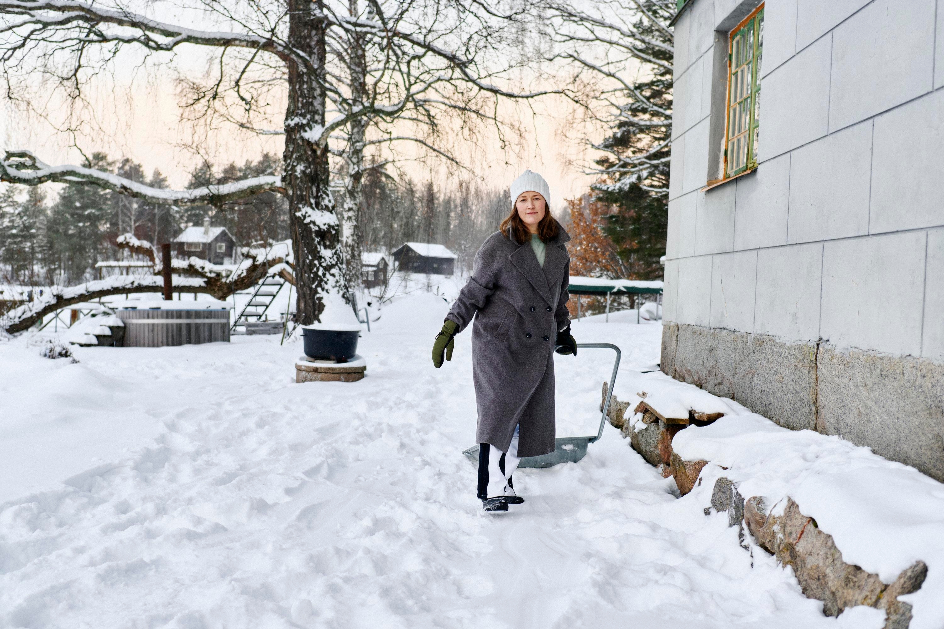 En kvinna skottar snö